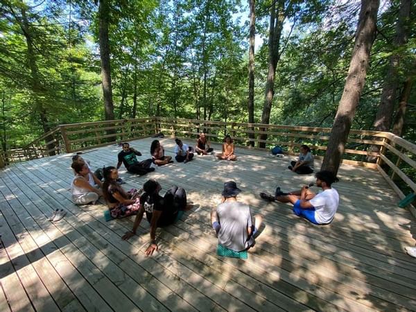 People sitting in circle on outside wooden deck
