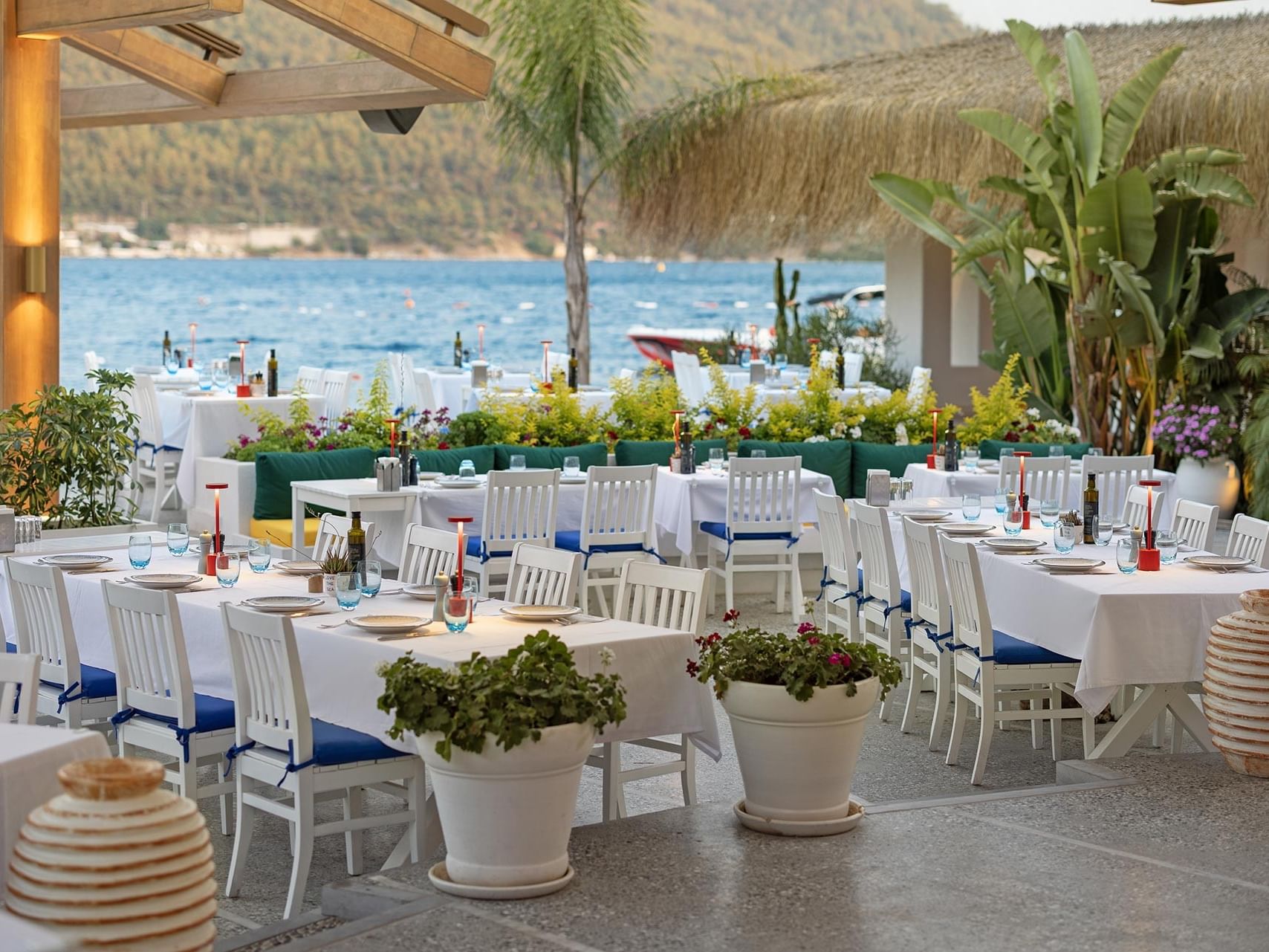 Sea-view open-air restaurant with elegant table settings at Titanic Luxury Collection Bodrum.