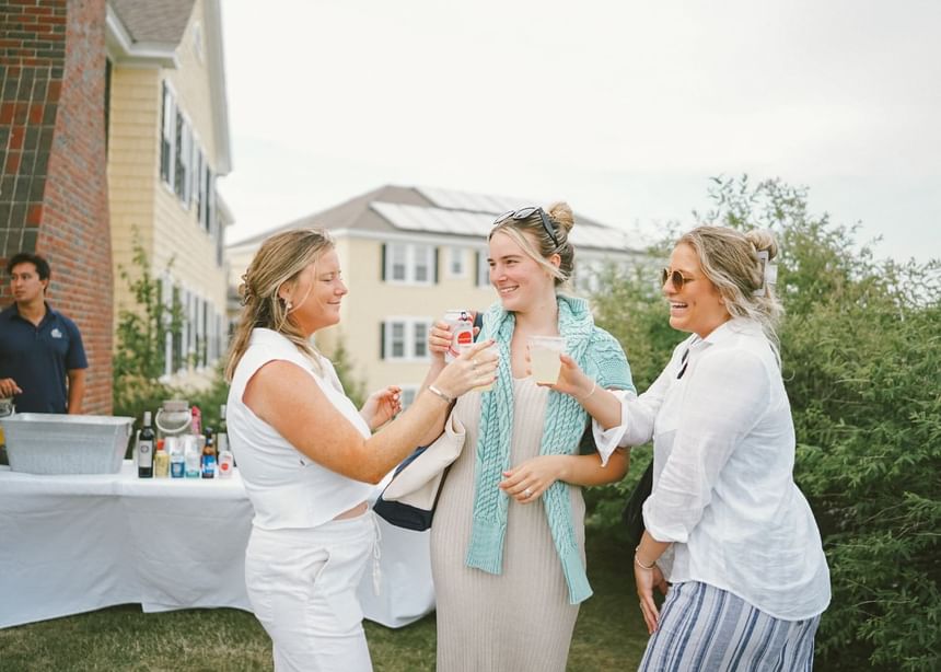 Ladies toasting drinks by an event held outdoors at Sebasco Harbor Resort