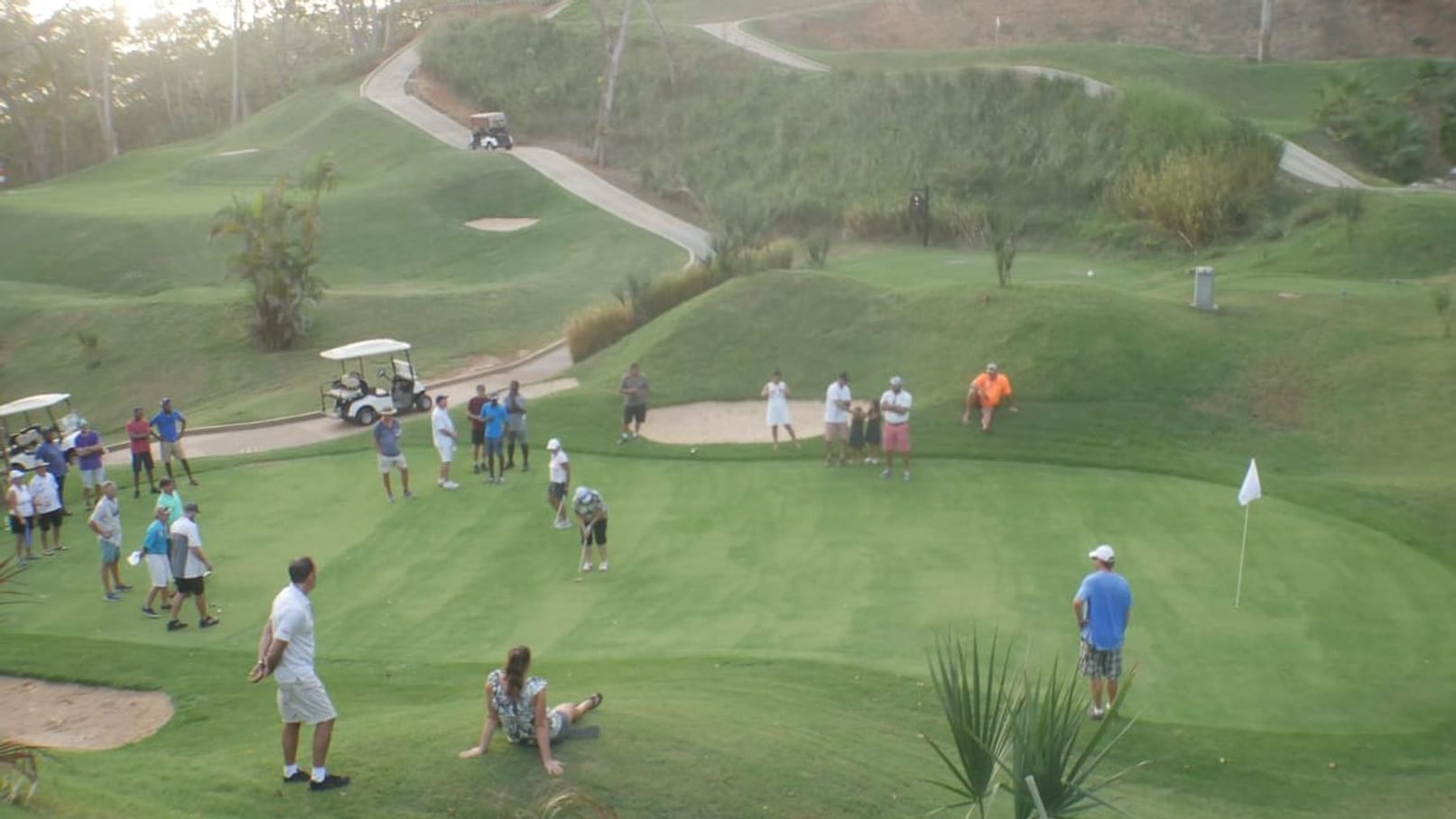 group playing golf with audience at Black Iguana Golf