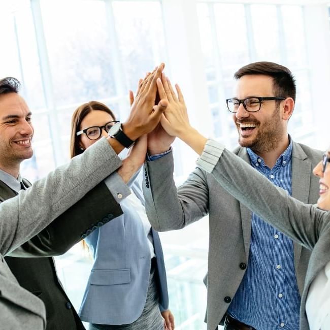 Colleagues high fiving after a successful business workshop