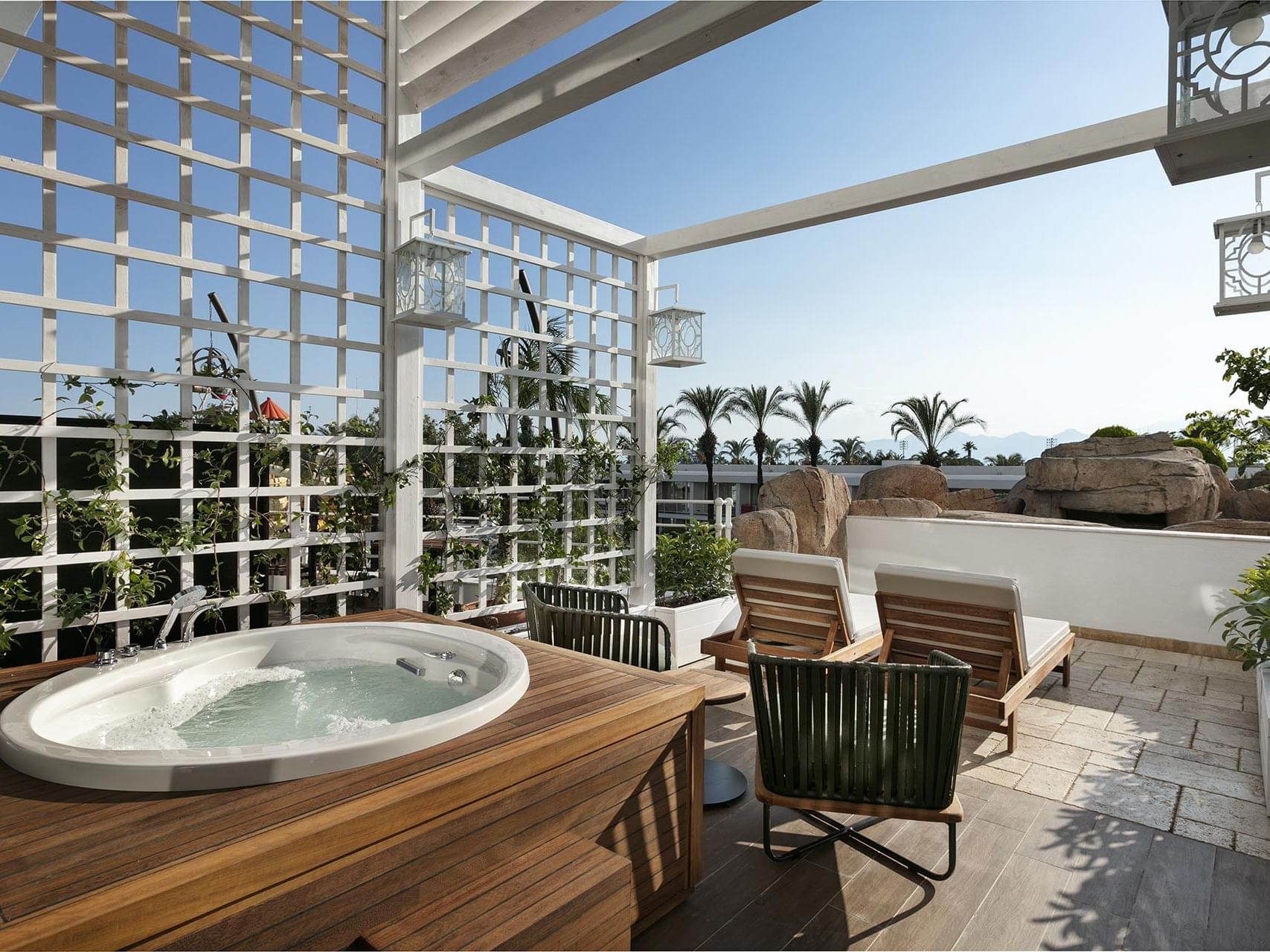 Sun loungers arranged by a hot jacuzzi outdoors in Duplex Suite at Titanic Deluxe Lara