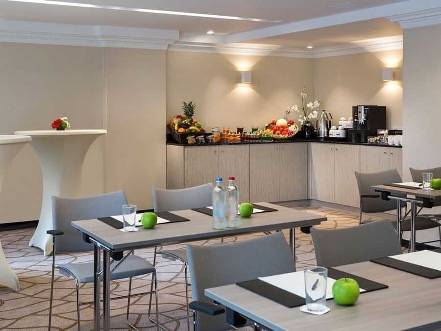 Classroom shape conference setup with a buffet station and fresh apples at Hotel Barsey by Warwick