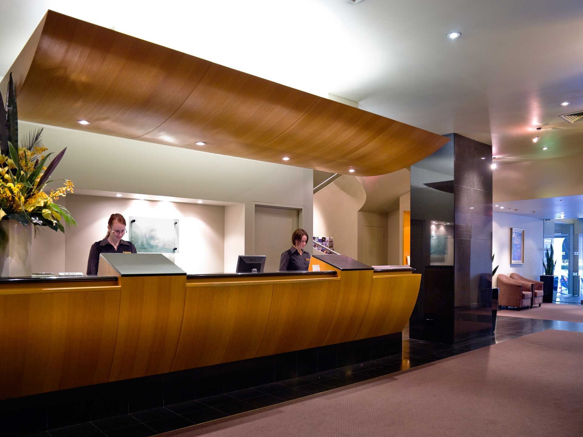 A hotel lobby with a reception desk and a grand wooden ceiling at Hotel Grand Chancellor Melbourne