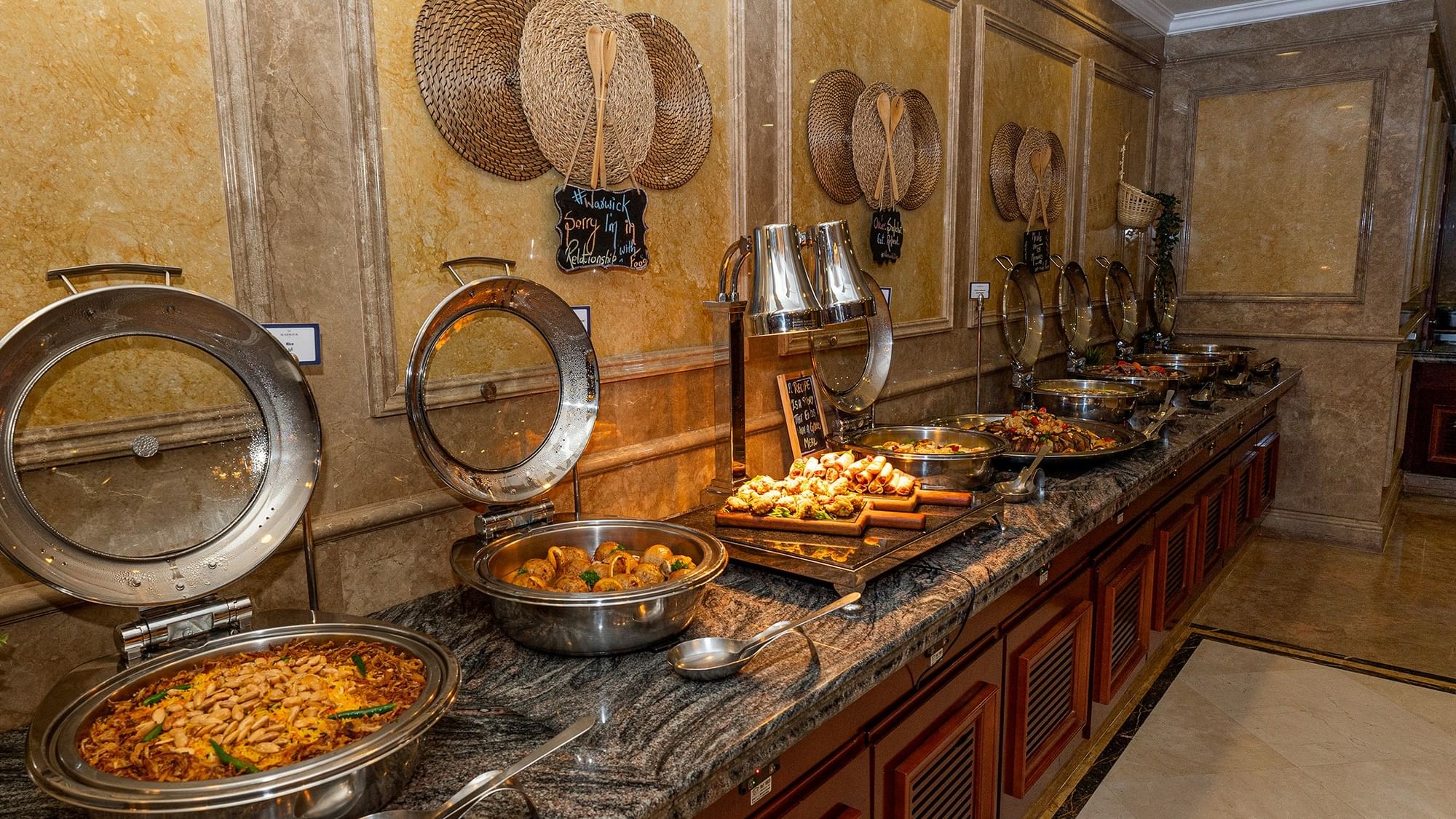 Buffet with various dishes and utensils at Warwick Doha in Doha.