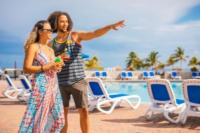 A couple by the pool enjoy the view at Holiday Inn Montego Bay