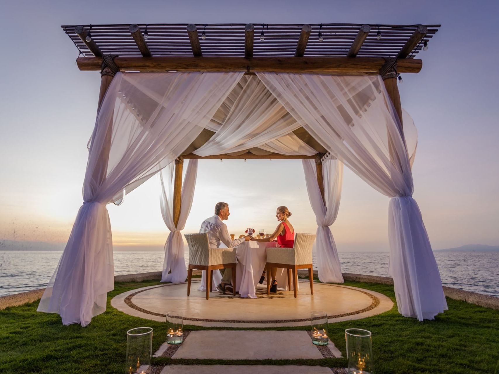 Couple dining under a pergola by the sea at Villa Premiere Boutique Hotel & Romantic Getaway