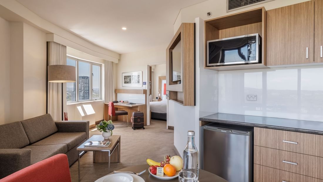 Superior Spa Suite interior with kitchenette, lounge area, and workspace at Novotel Sydney Olympic Park