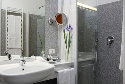 The bathroom vanity & shower in a room at Hotel Bisanzio
