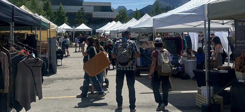 People visit vendors at an outdoor market in Canmore in summer.
