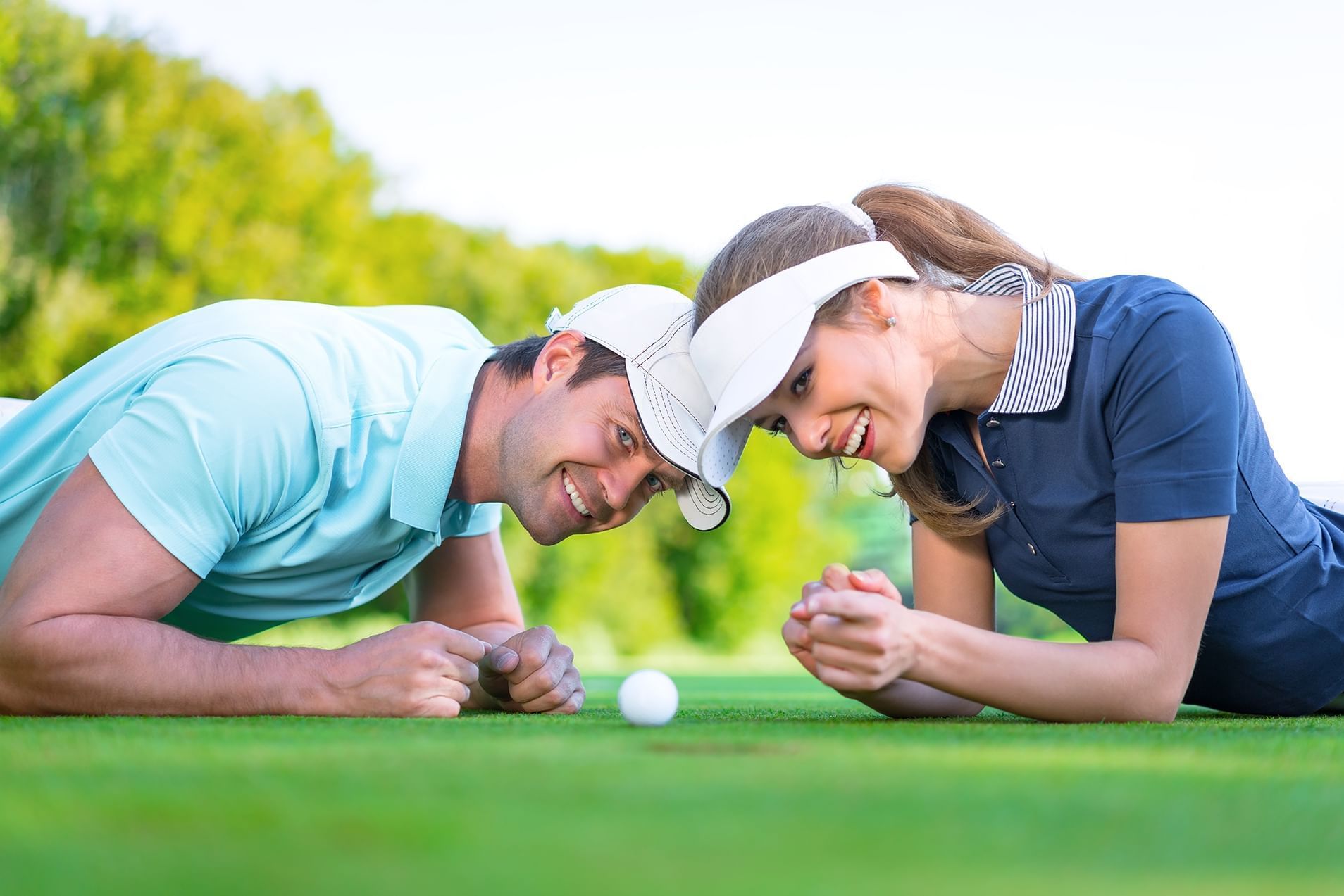 A man and a woman looking at a golf ball
