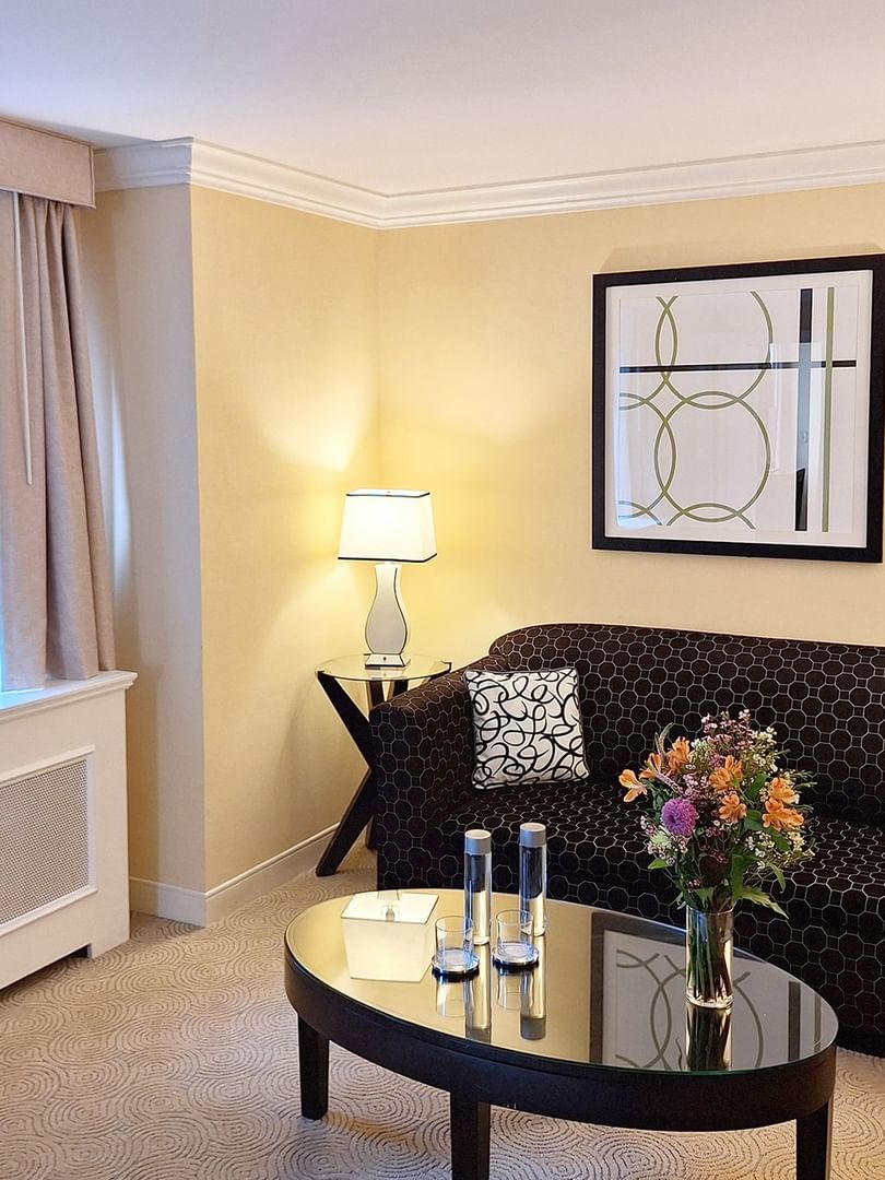 Patterned sofa with coffee table near window in Premium Suite Two Queen Beds at Warwick Allerton Chicago