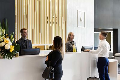People check in with receptionists at Alcyone Hotel Residences which is one of the hotels in Hamilton Brisbane