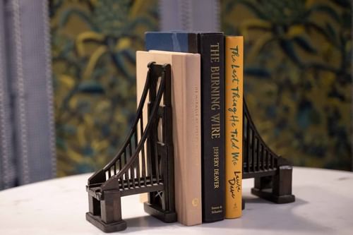 Bridge-shaped bookends holding popular novels on a marble table at El Prado Hotel