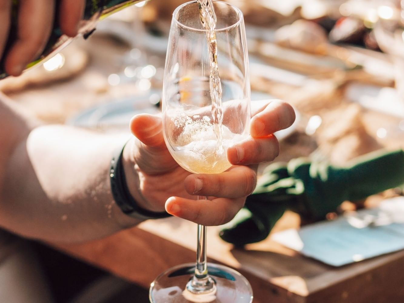 A man pouring champagne to a glass at Tally Ho Inn