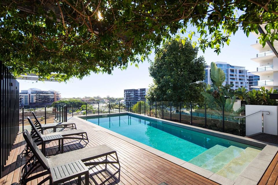 Outdoor pool with loungers and a scenic view of buildings at Alcyone Hotel Residences