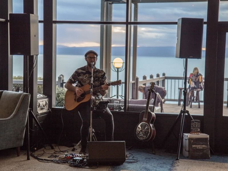 Solo singer playing the guitar on a set at Freycinet Lodge