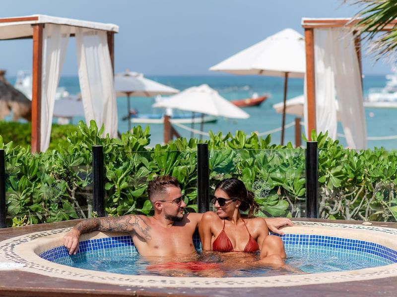 Couple spending time in outdoor jacuzzi at The Reef Coco Beach