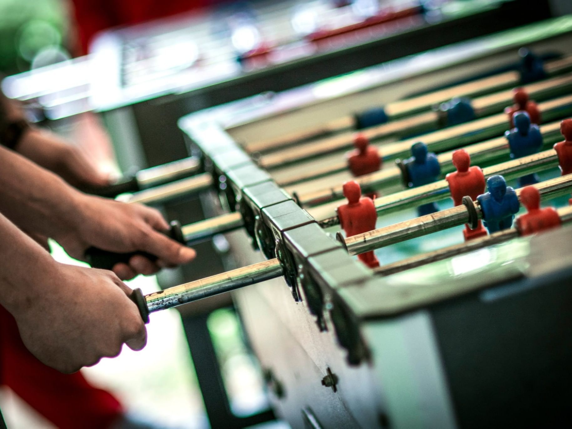 Close-up of two men playing foosball in the Game Room at The Bethel Inn Resort & Suites