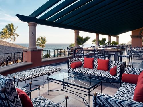 Patio con sofás estampados en blanco y negro con vista al mar en el Bar Santo Al Reves de Hacienda del Mar Los Cabos