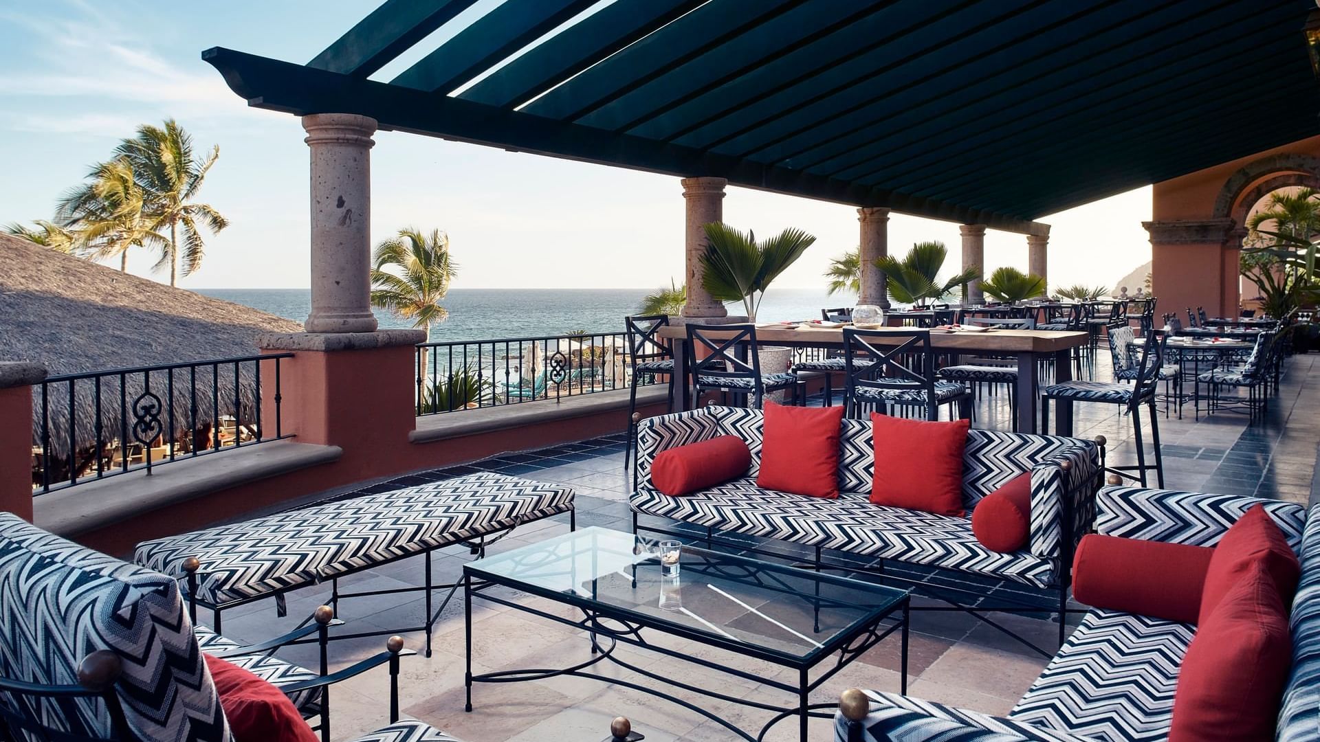 Patio con sofás estampados en blanco y negro con vista al mar en el Bar Santo Al Reves de Hacienda del Mar Los Cabos