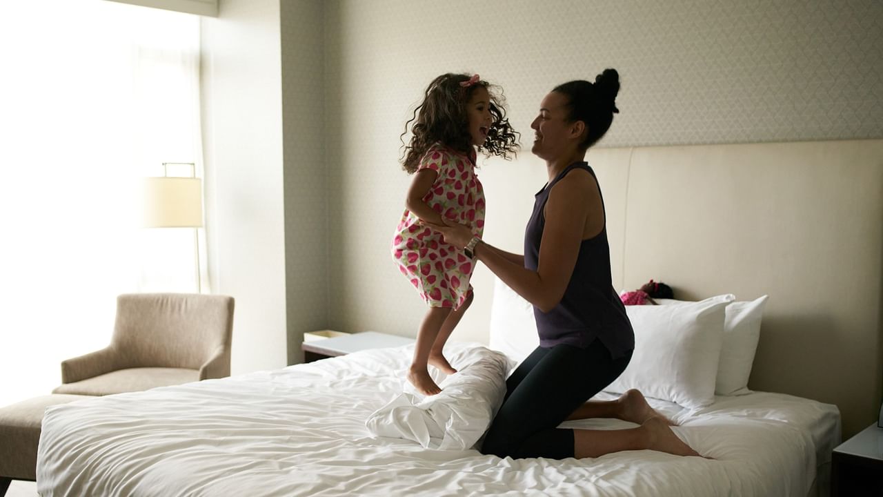 Adult and child playing on a hotel bed in Vancouver