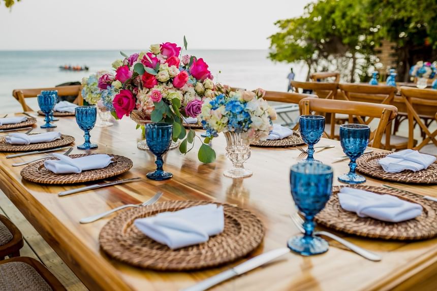 Close-up of a arrange table with floral deco by sea near Hotel Isla Del Encanto