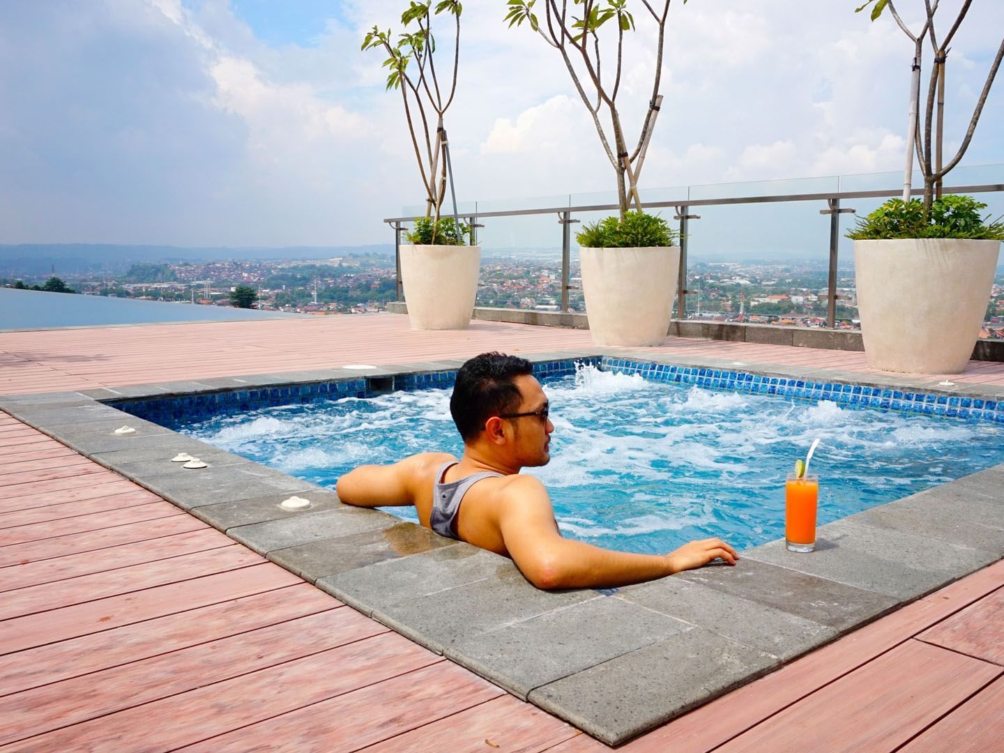 Man relaxing in jacuzzi while having a fresh juice at LK Pandanaran Hotel & Serviced Apartments