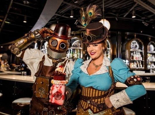A steampunk inspired robot and a woman in a blue dress and corset smile and hold a milkshake at Toothsome at Universal CityWalk Orlando.