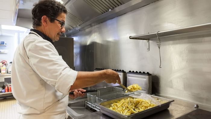 A picture of a chef cooking fresh fry at Hotel Du Phare