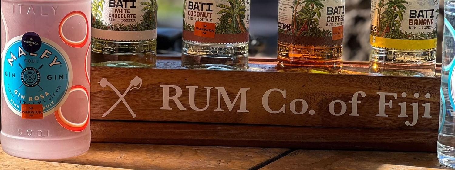 Bottles of Warwick Fiji rum displayed on wooden shelf at Warwick Fiji Resort and Spa
