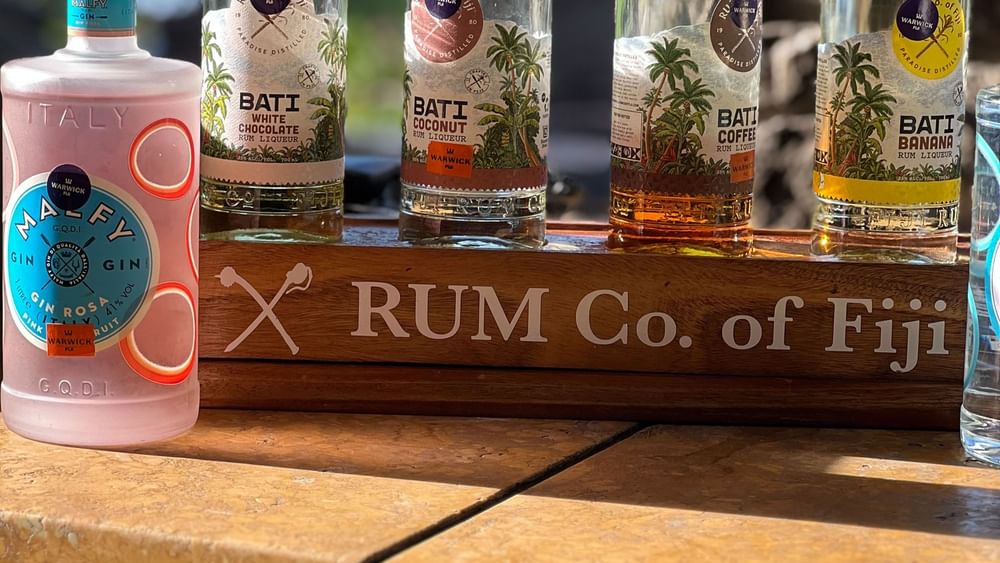Bottles of Warwick Fiji rum displayed on wooden shelf at Warwick Fiji Resort and Spa.