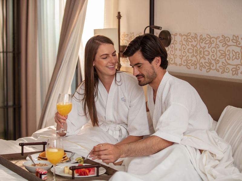 Couple having breakfast in the room at La Colección Resorts