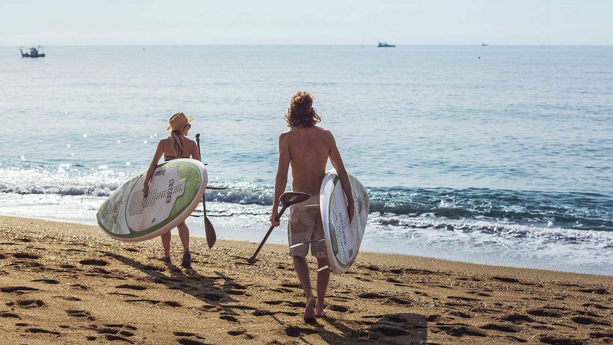 A couple surfing in a beach near Marbella Club Hotel