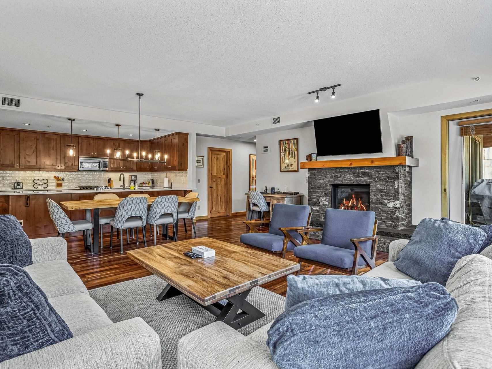 200 Rundle Cliffs Lodge Three Bedroom Premier Condo living room with fireplace and open kitchen at Spring Creek Vacations