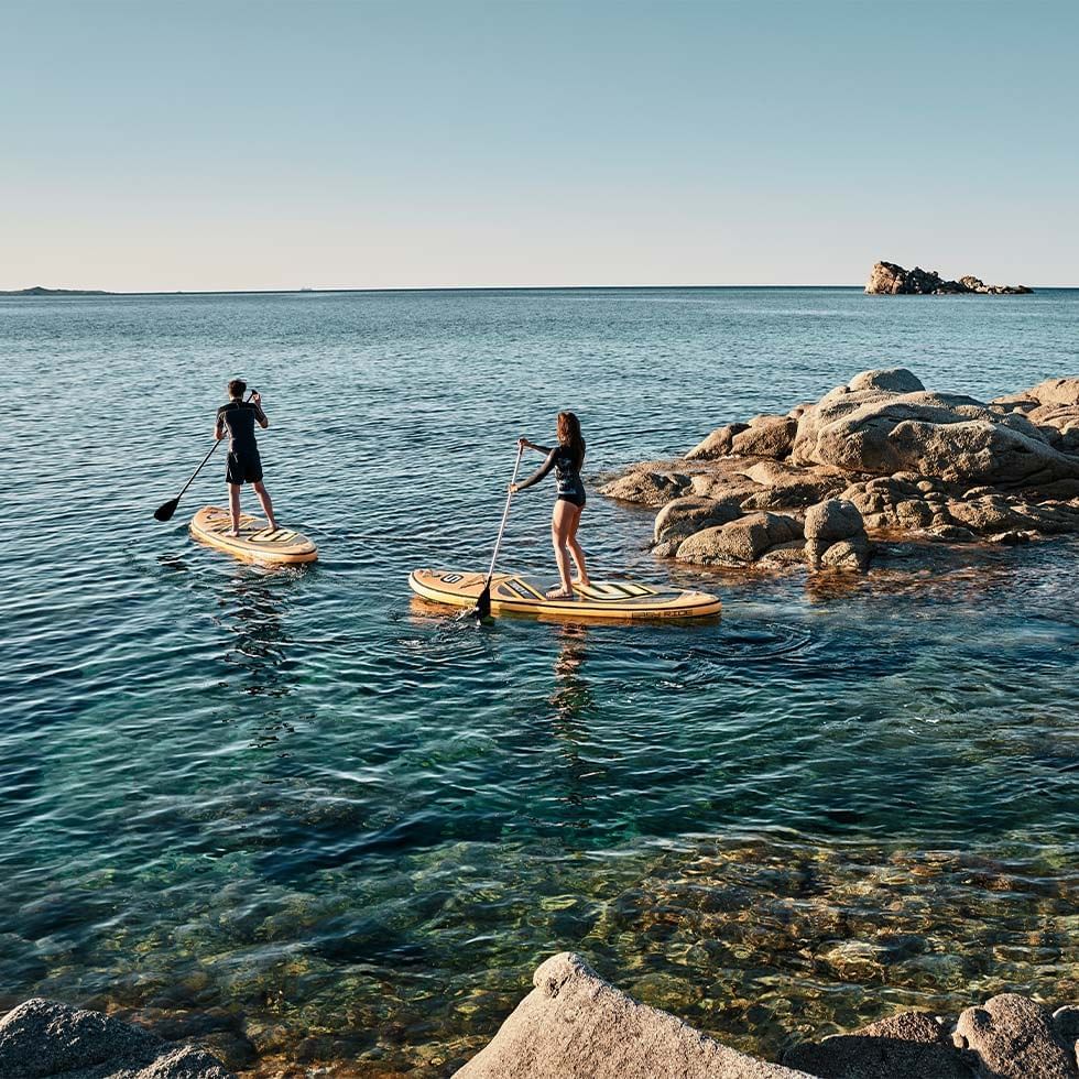 A couple paddling in the sea near Falkensteiner Hotels