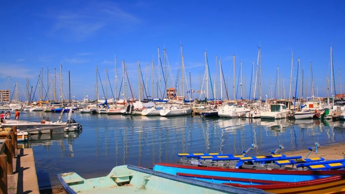 Wide shot of a port with yachts near the Originals Hotels