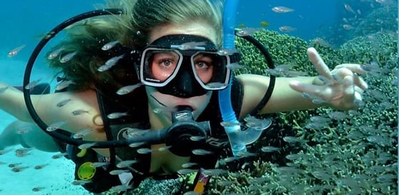 Closeup on a female scuba diver by a reef near Infinity Bay