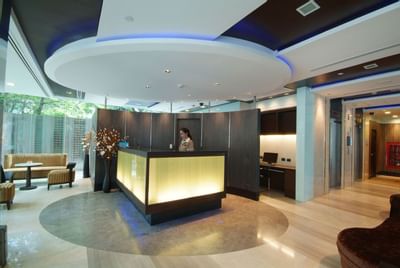 Lobby area with front desk and receptionist at Amora Neoluxe Hotel Bangkok