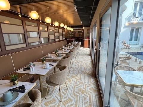 Vue élégante du restaurant de l'Hôtel Le Yachtman avec tables et chaises chics.