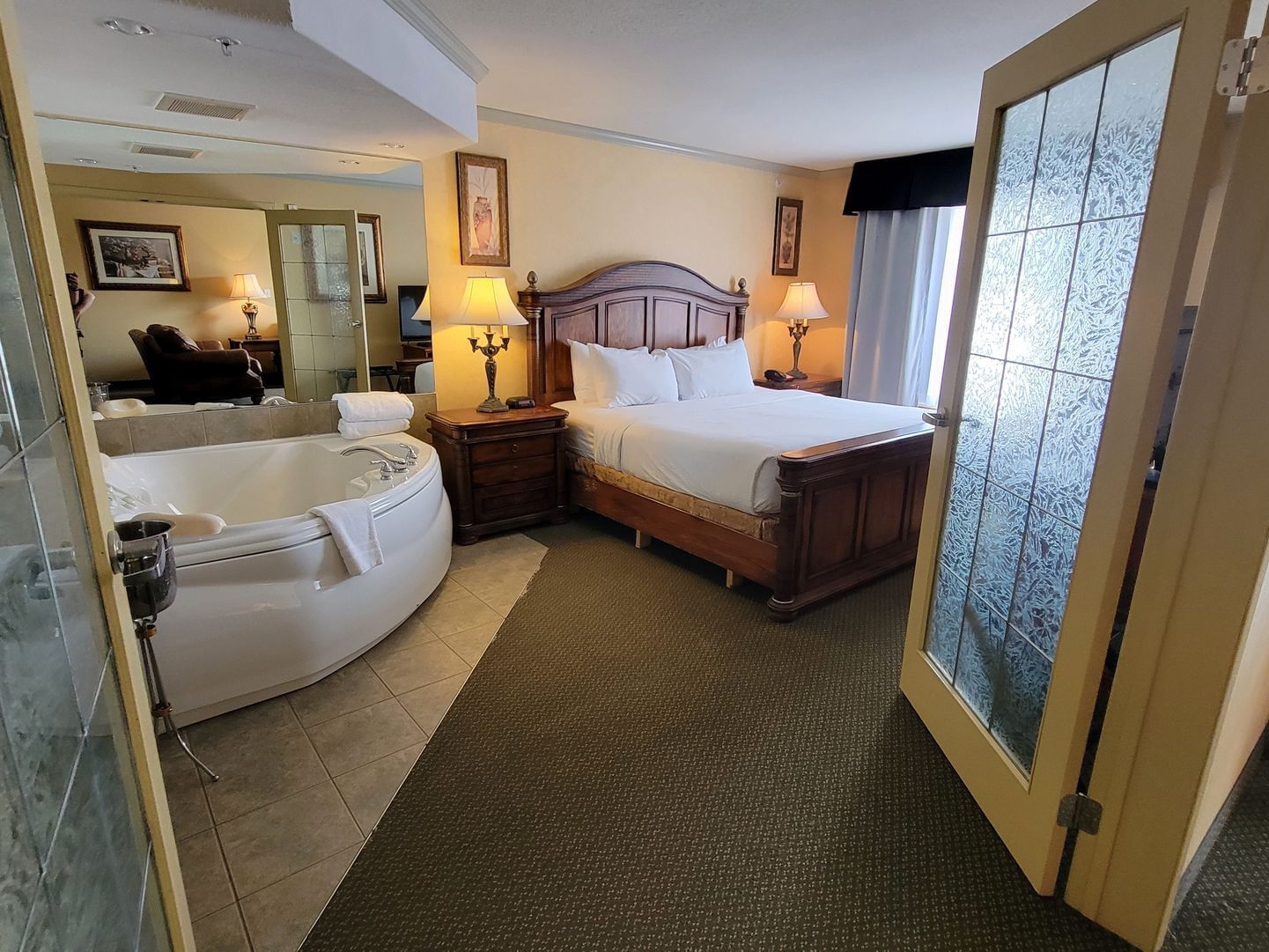 Jetted tub & nightstands by the bed in Royal Suite at Merit Hotel & Suites, Fort McMurray