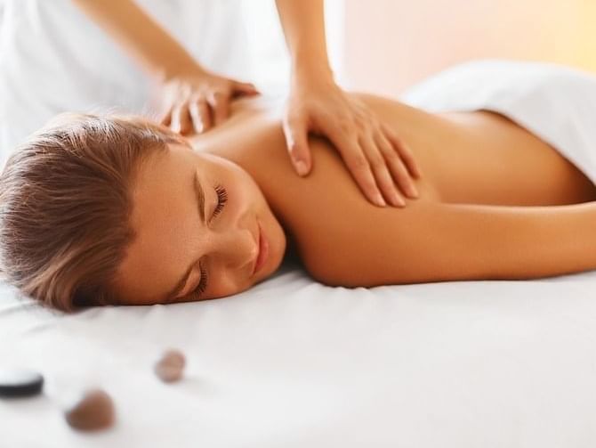 A lady having a body massage in the spa at The Grove Hotel