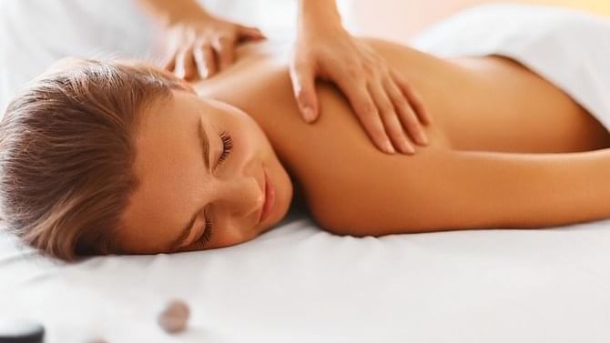 A lady having a body massage in the spa at The Grove Hotel