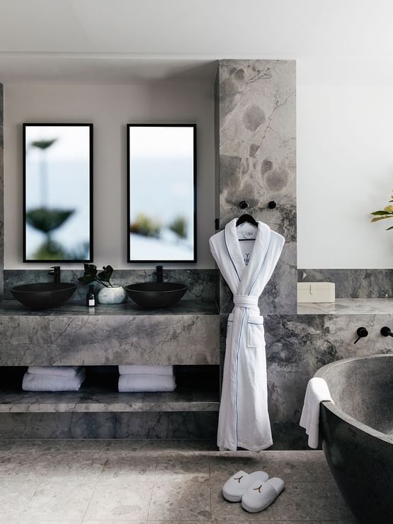 Elysium Two Bedroom Suite at Elysium Manly with a black tub by twin sinks under mirrors, offering cozy Manly accommodation