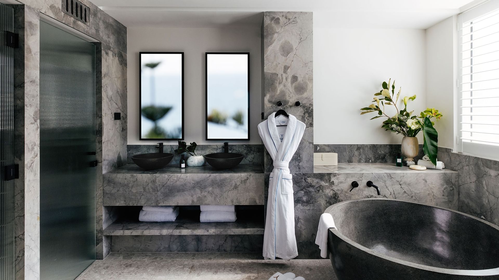 Elysium Two Bedroom Suite at Elysium Manly with a black tub by twin sinks under mirrors, offering cozy Manly accommodation