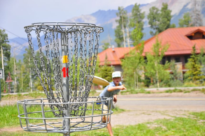 A child playing disc golf at Elegante Lodge & Resort Ruidoso