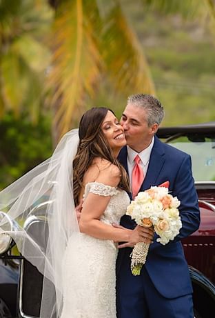 Groom kissing a bride in Copa Gardens at Copamarina Weddings