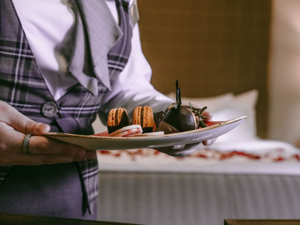 Close-up of a waiter bringing a Macaron at The Malcolm Hotel