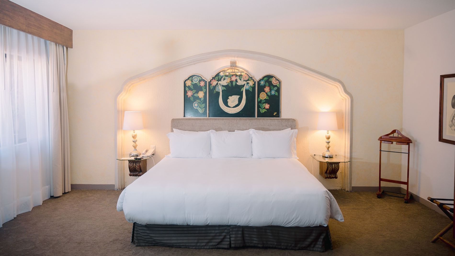 King Grand Class room at Quinta Real Zacatecas, featuring white linens and a traditional arched wall alcove