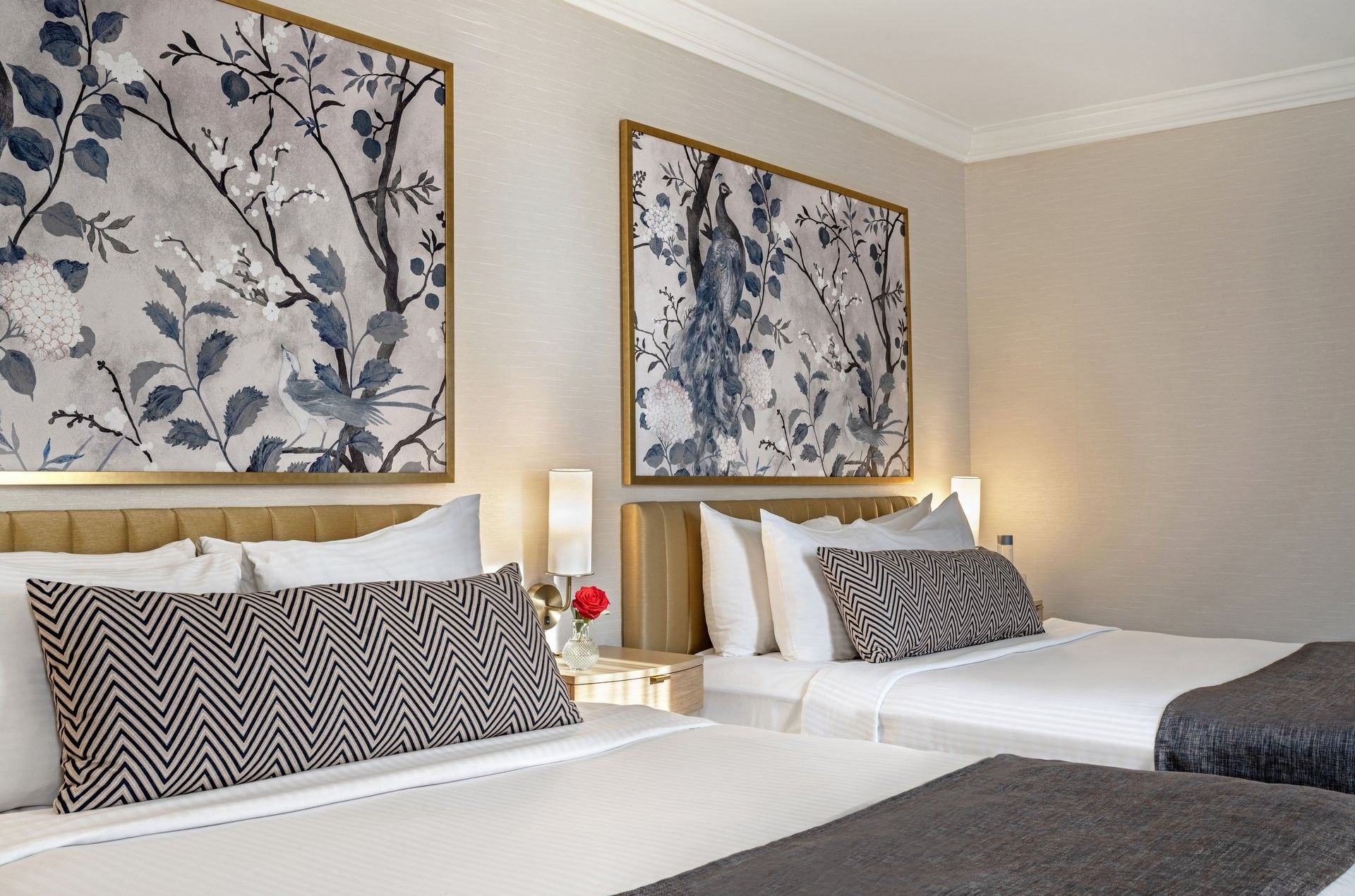 Two beds with large pillows and blue floral wall art in a hotel room at Warwick Allerton Chicago